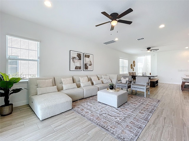 living area with visible vents, ceiling fan, and light wood-style flooring