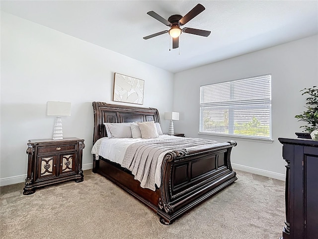 bedroom with ceiling fan, light carpet, and baseboards