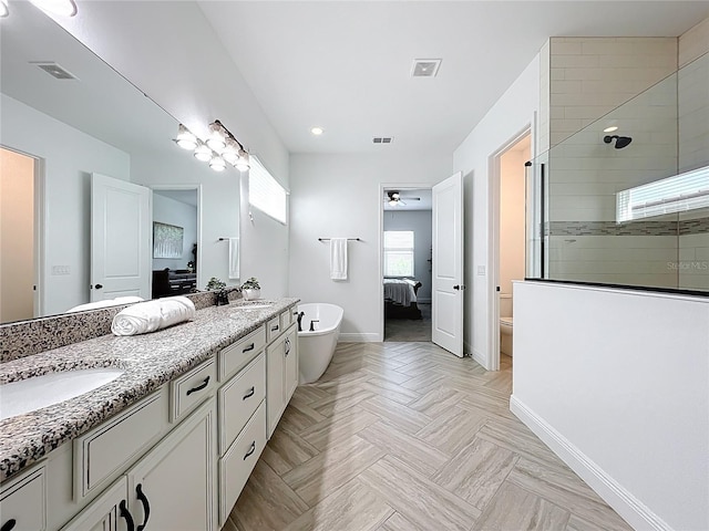 bathroom featuring a tile shower, a sink, a soaking tub, and baseboards