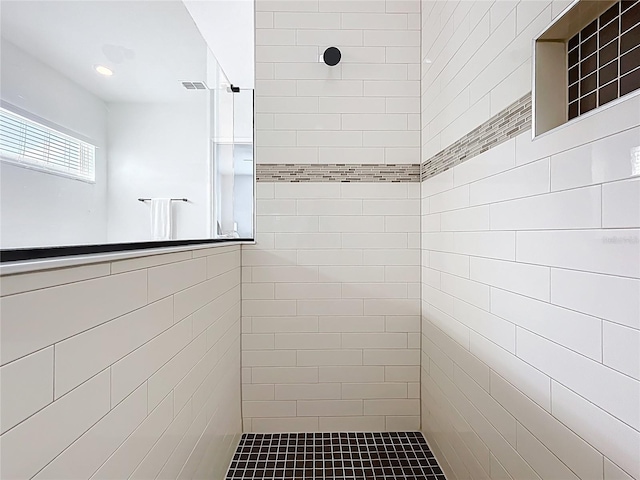 full bathroom featuring visible vents and a tile shower