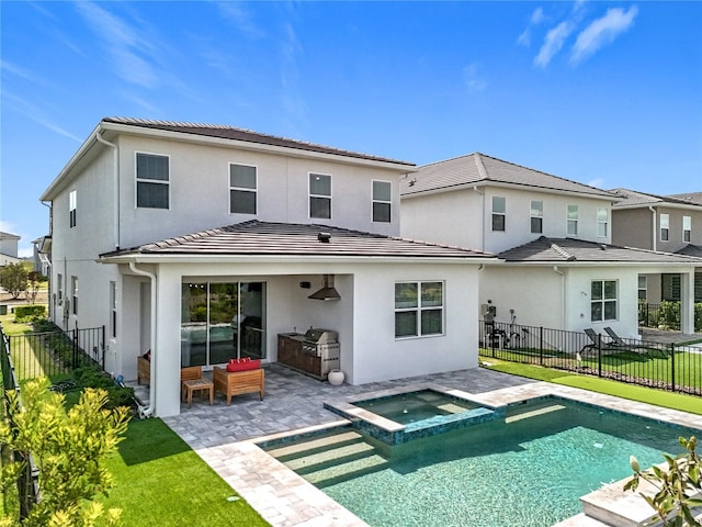 rear view of property with stucco siding, exterior kitchen, a patio area, and a fenced backyard