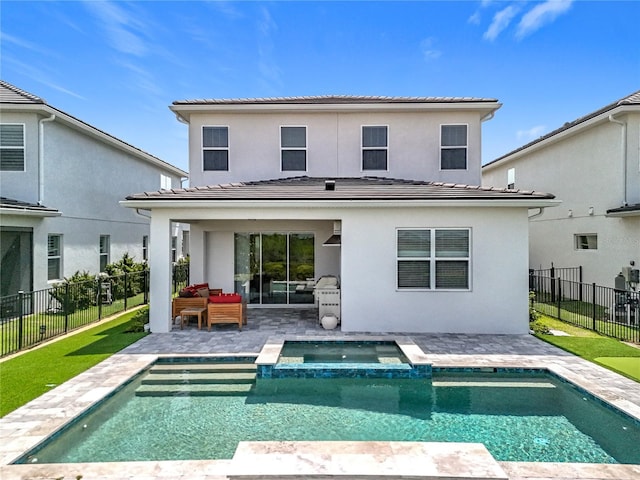 rear view of house with a tile roof, stucco siding, and a patio area