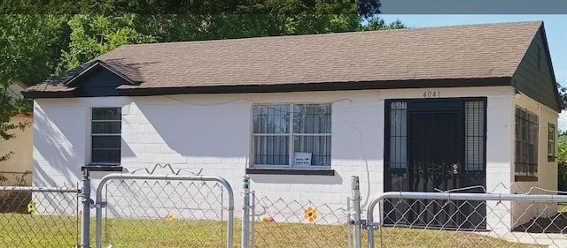 view of side of home featuring a gate, roof with shingles, and a fenced front yard