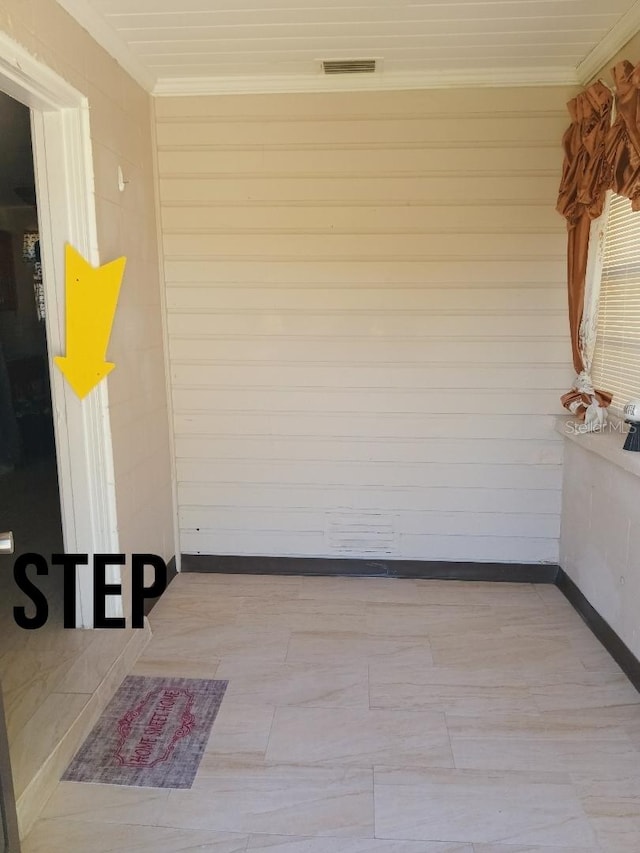 interior space featuring baseboards, ornamental molding, and visible vents