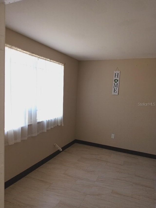 empty room featuring baseboards