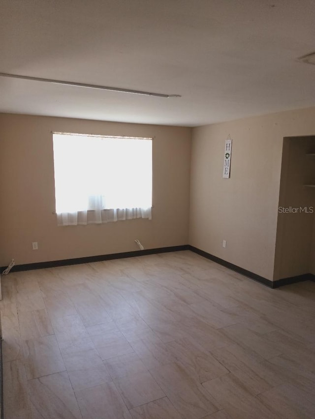 spare room with baseboards