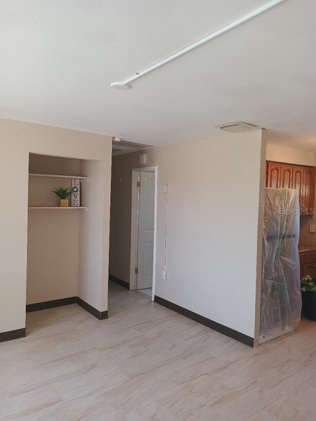 unfurnished room with baseboards