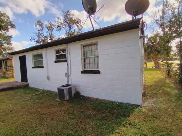 view of outdoor structure featuring central AC and fence