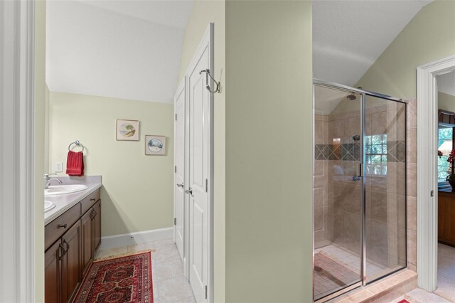 4000 Rouse Rd, Orlando, FL 32817 - bathroom with a sink, a shower stall, double vanity, tile patterned flooring, and lofted ceiling