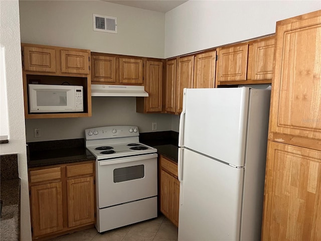3344 Corona Village Way Unit 205, Orlando, FL 32835 - kitchen featuring dark countertops, white appliances, light tile patterned floors, under cabinet range hood, and visible vents