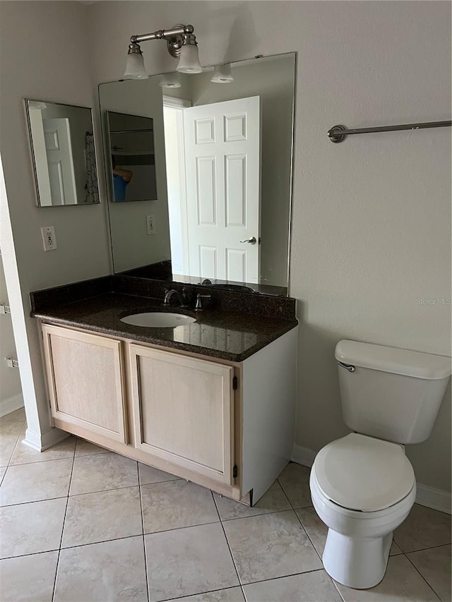3344 Corona Village Way Unit 205, Orlando, FL 32835 - bathroom featuring baseboards, toilet, vanity, and tile patterned floors
