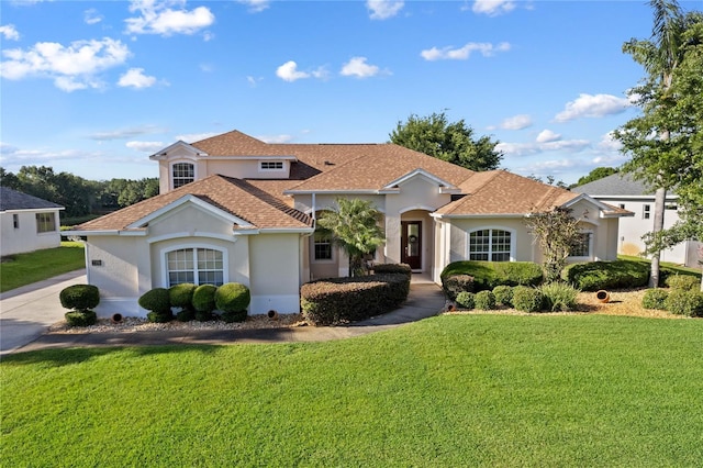 mediterranean / spanish house with a front yard and stucco siding