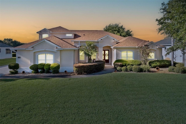 7351 Spring Mountain Ln, Yalaha, FL 34797 - mediterranean / spanish house featuring french doors, a front yard, and stucco siding