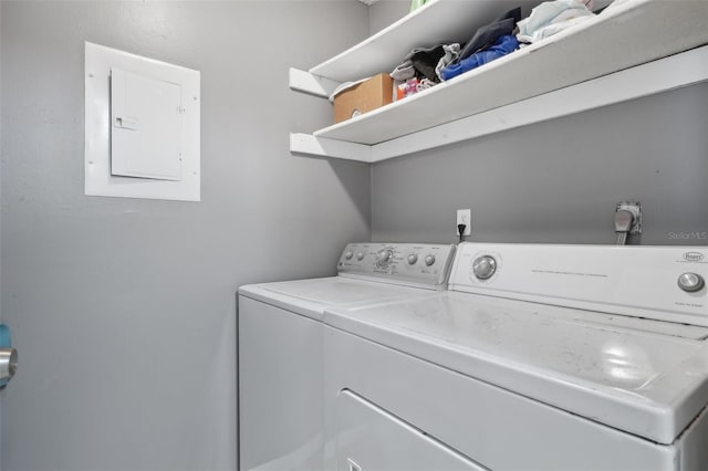 washroom featuring washing machine and dryer, electric panel, and laundry area