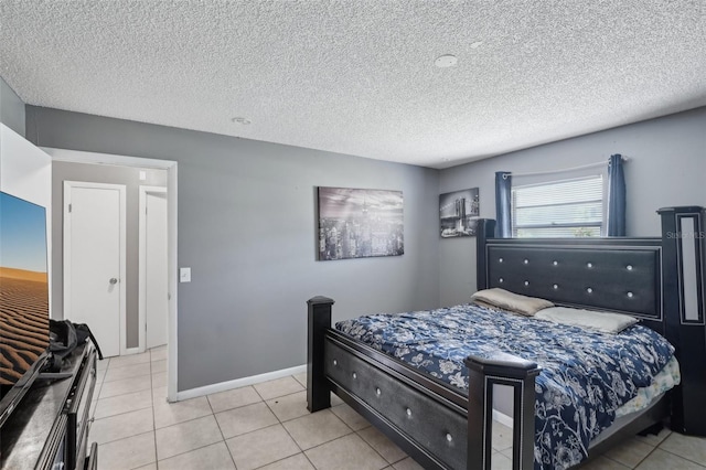 tiled bedroom featuring baseboards and a textured ceiling