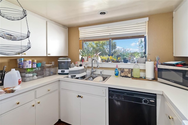 kitchen featuring a healthy amount of sunlight, a sink, light countertops, stainless steel microwave, and black dishwasher