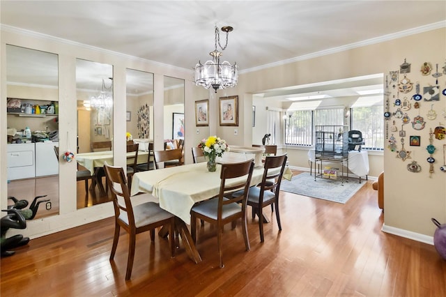 dining room featuring an inviting chandelier, ornamental molding, and wood finished floors