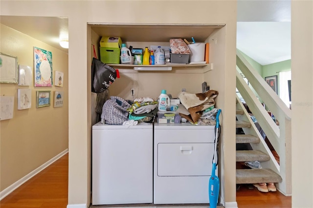washroom featuring baseboards, laundry area, independent washer and dryer, and wood finished floors