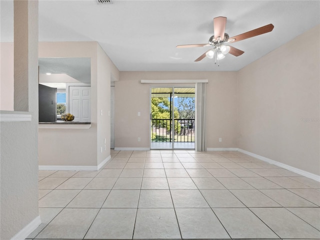 spare room with baseboards, a ceiling fan, and tile patterned flooring