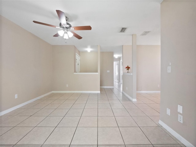 spare room featuring baseboards, a ceiling fan, visible vents, and light tile patterned floors