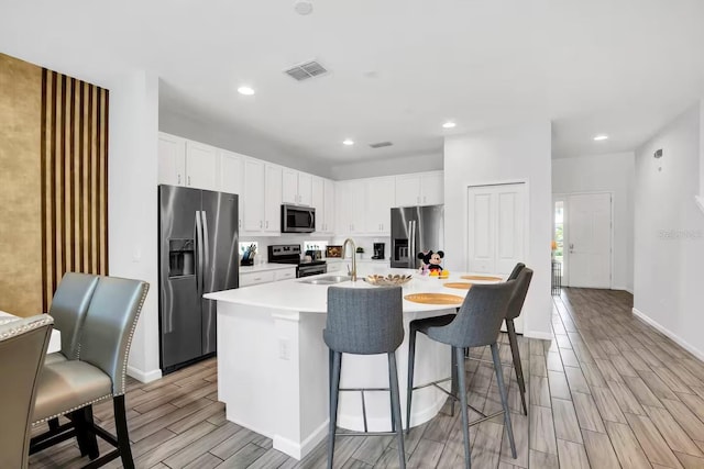 2616 Calistoga Ave, Kissimmee, FL 34741 - kitchen featuring stainless steel appliances, light countertops, white cabinets, wood finish floors, and visible vents