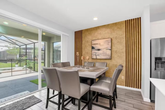 2616 Calistoga Ave, Kissimmee, FL 34741 - dining area featuring an accent wall, wood finish floors, baseboards, a sunroom, and recessed lighting
