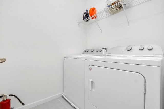2616 Calistoga Ave, Kissimmee, FL 34741 - clothes washing area with baseboards, washer and dryer, laundry area, and light tile patterned floors