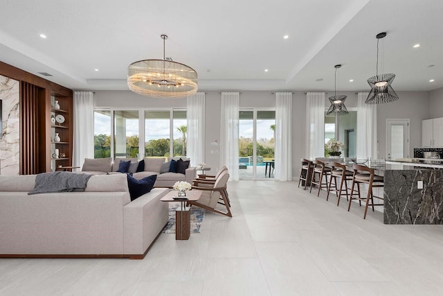 living area with recessed lighting, a healthy amount of sunlight, and an inviting chandelier