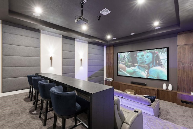 carpeted home theater room with visible vents, recessed lighting, and a raised ceiling