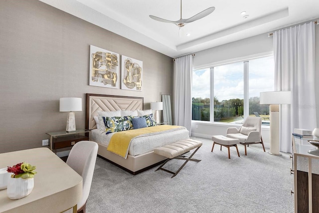 bedroom featuring a ceiling fan, carpet flooring, and a raised ceiling