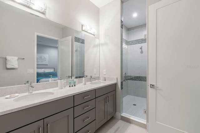 full bath with a sink, a shower stall, double vanity, and connected bathroom