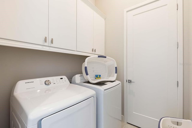 washroom featuring cabinet space and washing machine and clothes dryer