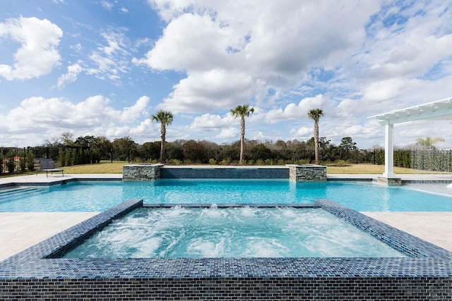 view of swimming pool with fence and a pool with connected hot tub