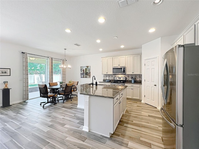 865 Bay Bridge Cir, Apopka, FL 32703 - kitchen with appliances with stainless steel finishes, a sink, recessed lighting, light wood-style flooring, and a chandelier