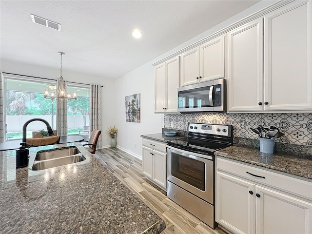 865 Bay Bridge Cir, Apopka, FL 32703 - kitchen with stainless steel appliances, a sink, a chandelier, light wood-type flooring, and backsplash