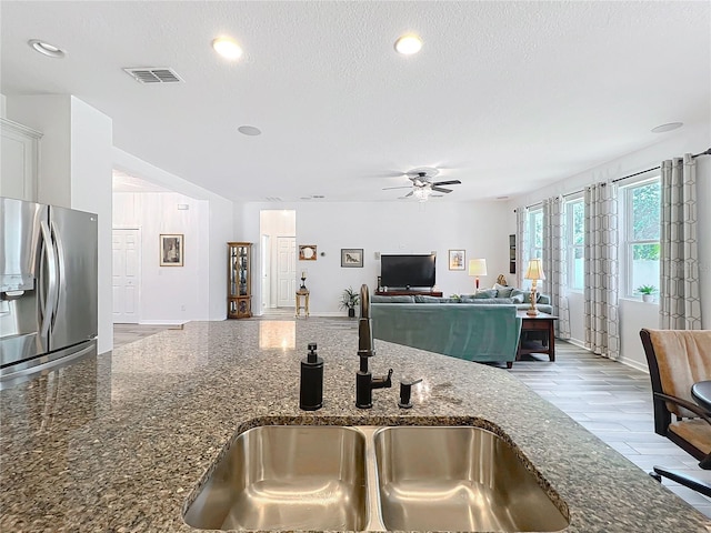865 Bay Bridge Cir, Apopka, FL 32703 - kitchen featuring stainless steel fridge with ice dispenser, a sink, a ceiling fan, dark stone counters, and white cabinets