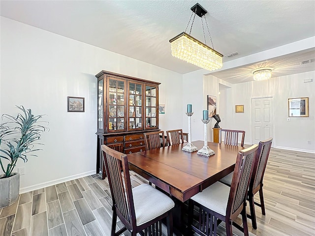 865 Bay Bridge Cir, Apopka, FL 32703 - dining room featuring light wood finished floors, baseboards, and a chandelier