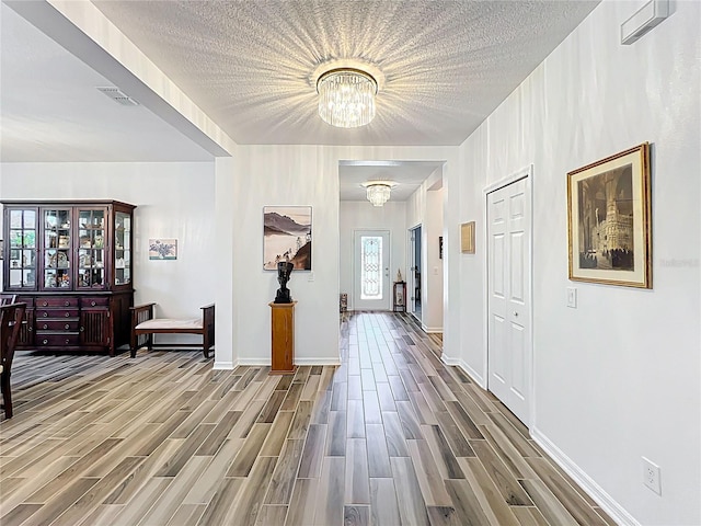 865 Bay Bridge Cir, Apopka, FL 32703 - corridor featuring a chandelier, wood finished floors, baseboards, and a textured ceiling