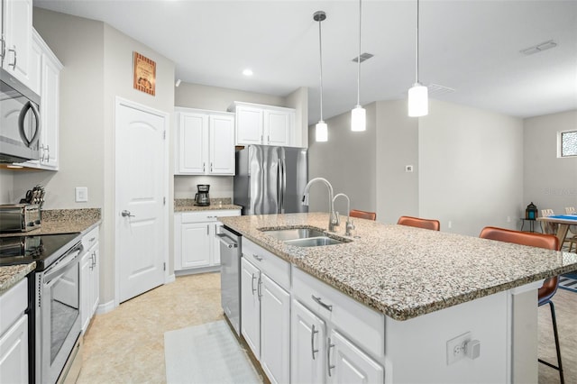 1540 Softshell St, Saint Cloud, FL 34771 - kitchen with an island with sink, a kitchen breakfast bar, visible vents, a sink, and appliances with stainless steel finishes