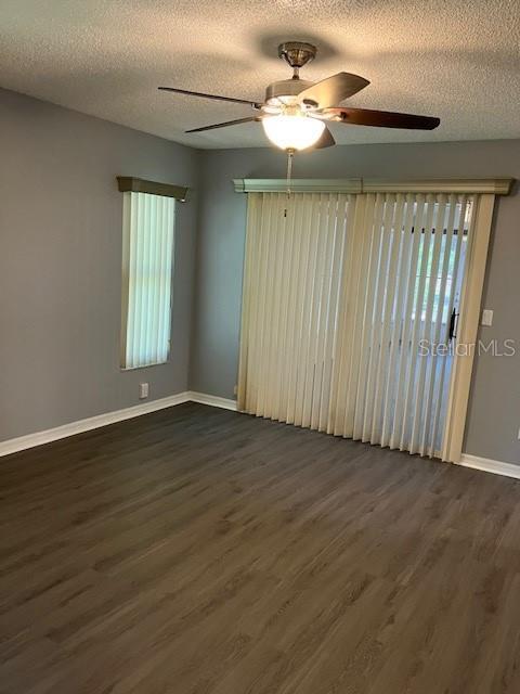 6419 Borg St, Leesburg, FL 34748 - unfurnished room with baseboards, a ceiling fan, dark wood-type flooring, and a textured ceiling