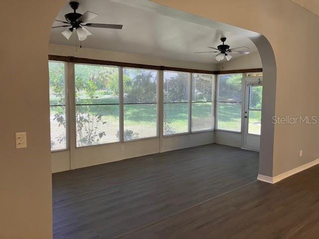 6419 Borg St, Leesburg, FL 34748 - unfurnished sunroom featuring arched walkways, wood finished floors, a healthy amount of sunlight, and baseboards