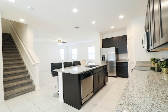 kitchen with a sink, an island with sink, ceiling fan, appliances with stainless steel finishes, and visible vents