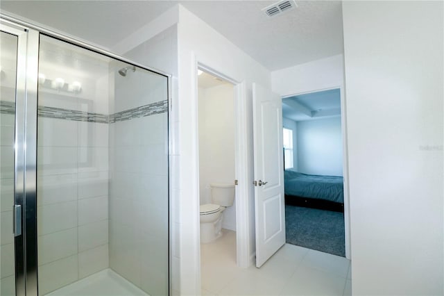 ensuite bathroom featuring a stall shower, toilet, ensuite bathroom, visible vents, and tile patterned flooring