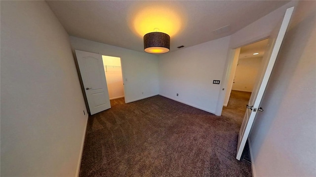 spare room with baseboards and carpet floors