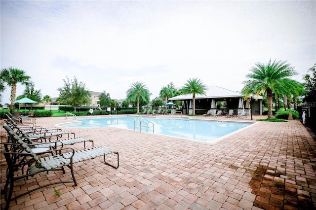 pool with a patio and fence