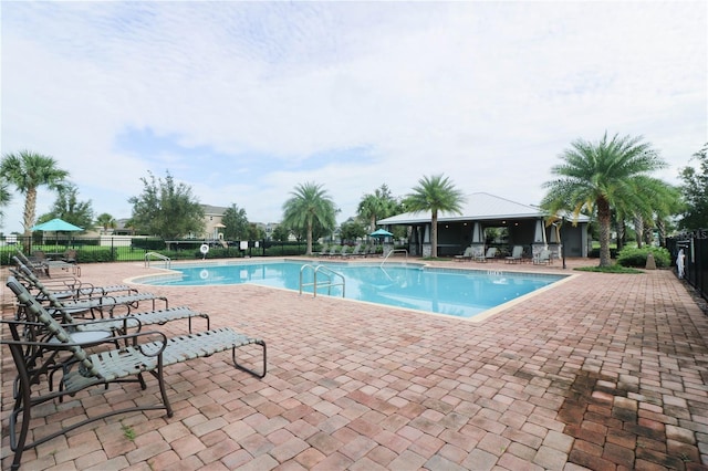 community pool with fence, a patio, and a gazebo