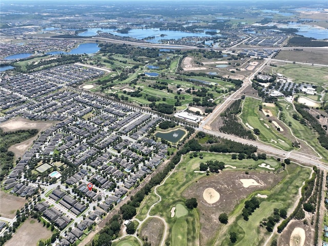 drone / aerial view with golf course view, a residential view, and a water view