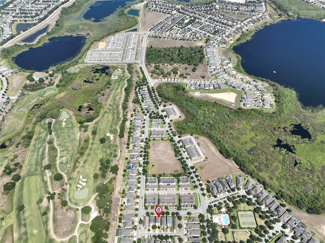 drone / aerial view with golf course view and a water view