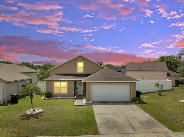 5118 Luna Negra Dr, Orlando, FL 32811 - view of front facade with a yard, an attached garage, concrete driveway, and fence