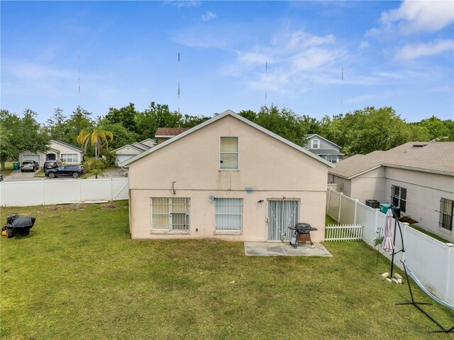 5118 Luna Negra Dr, Orlando, FL 32811 - rear view of property with a patio, a fenced backyard, a yard, and stucco siding